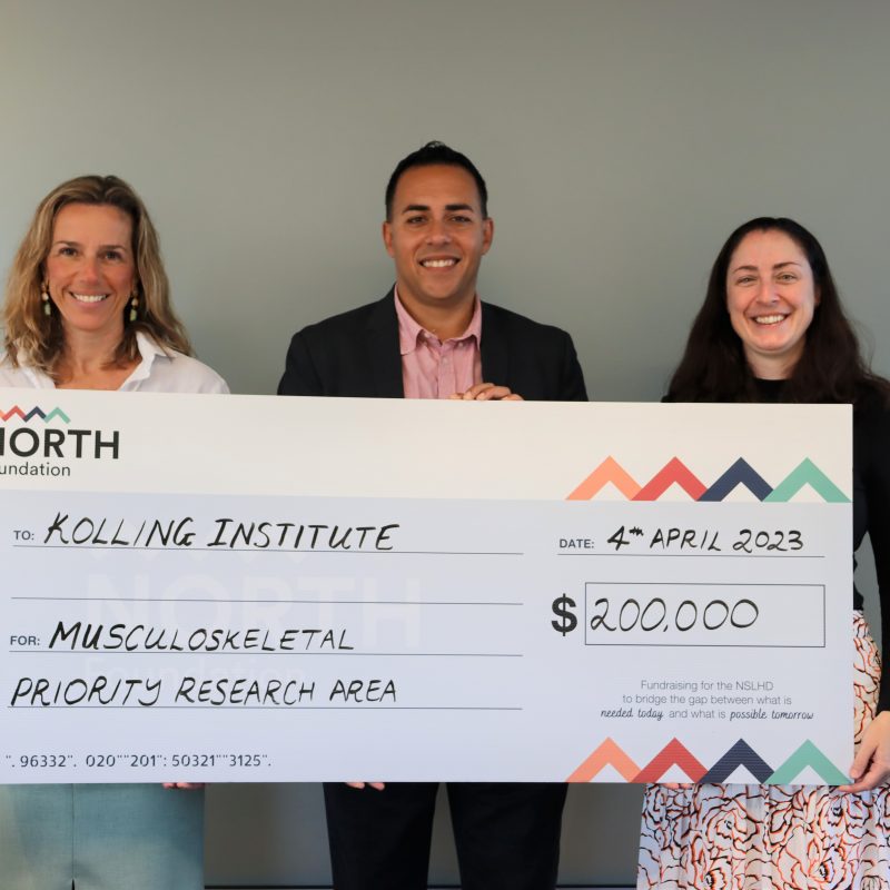 Two ladies and one man holding a $200,000 cheque