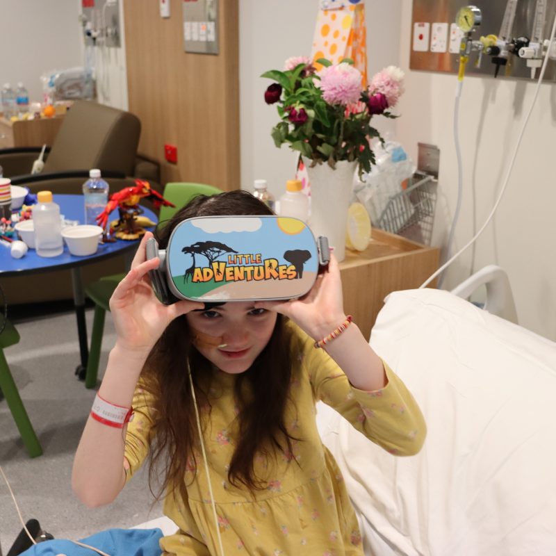 Little girl on hospital bed with virtual reality goggles
