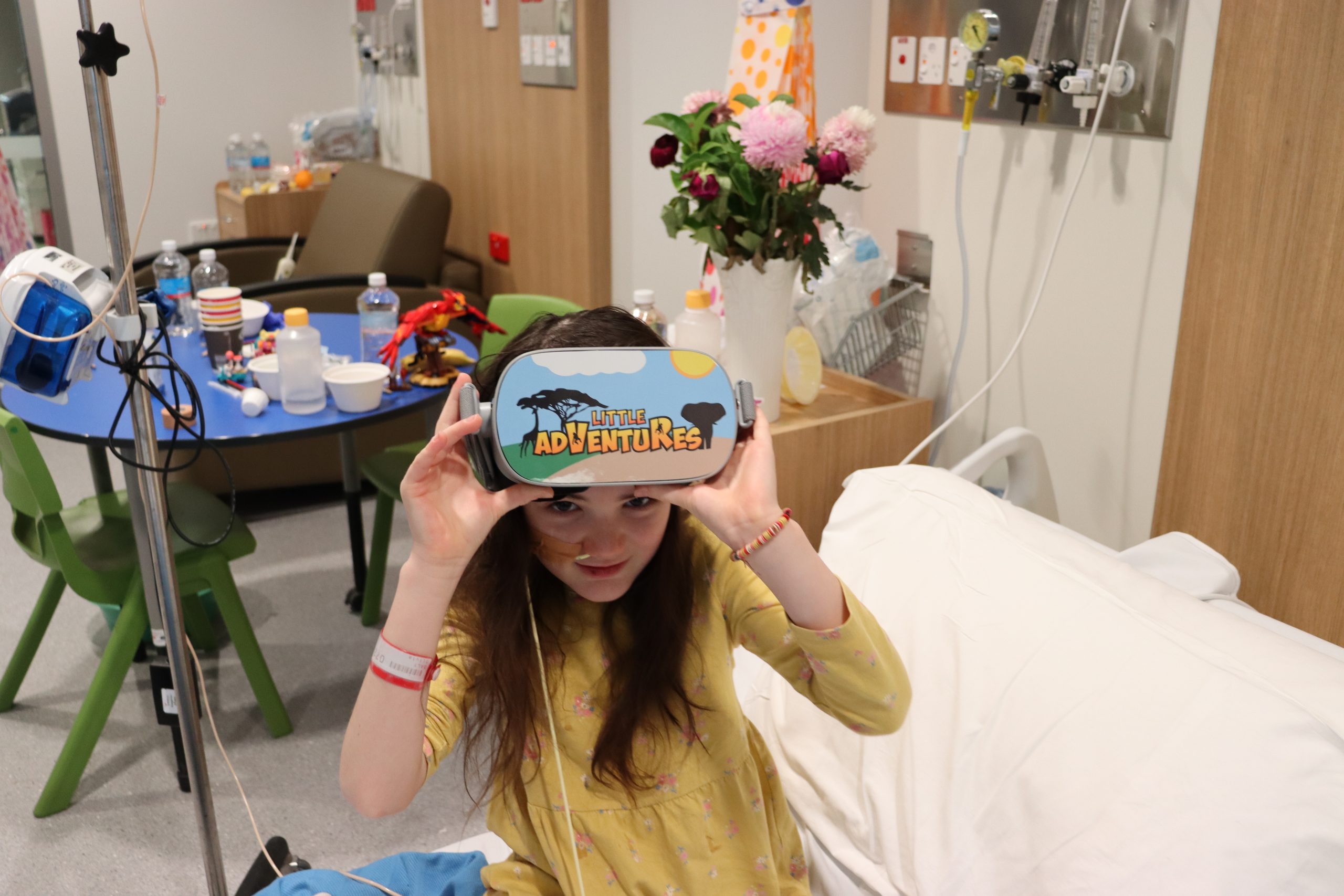 Little girl on hospital bed with virtual reality goggles