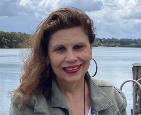 Woman staying in front of a lake smiling