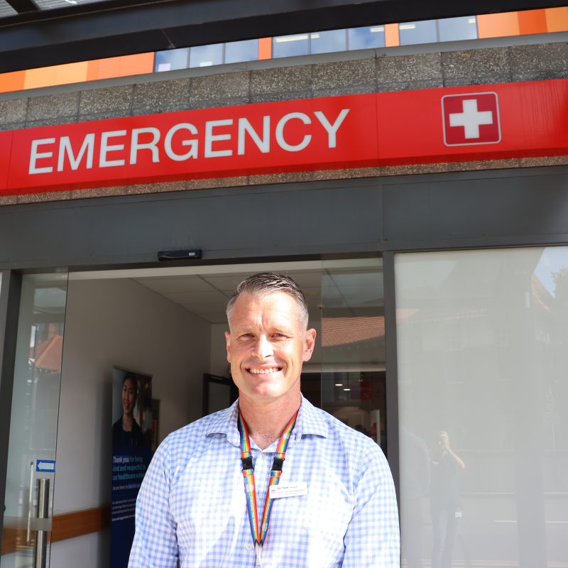 Man standing under an emergency sign